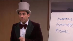Michael Scott dressed as Willy Wonka, presenting his Golden Ticket idea